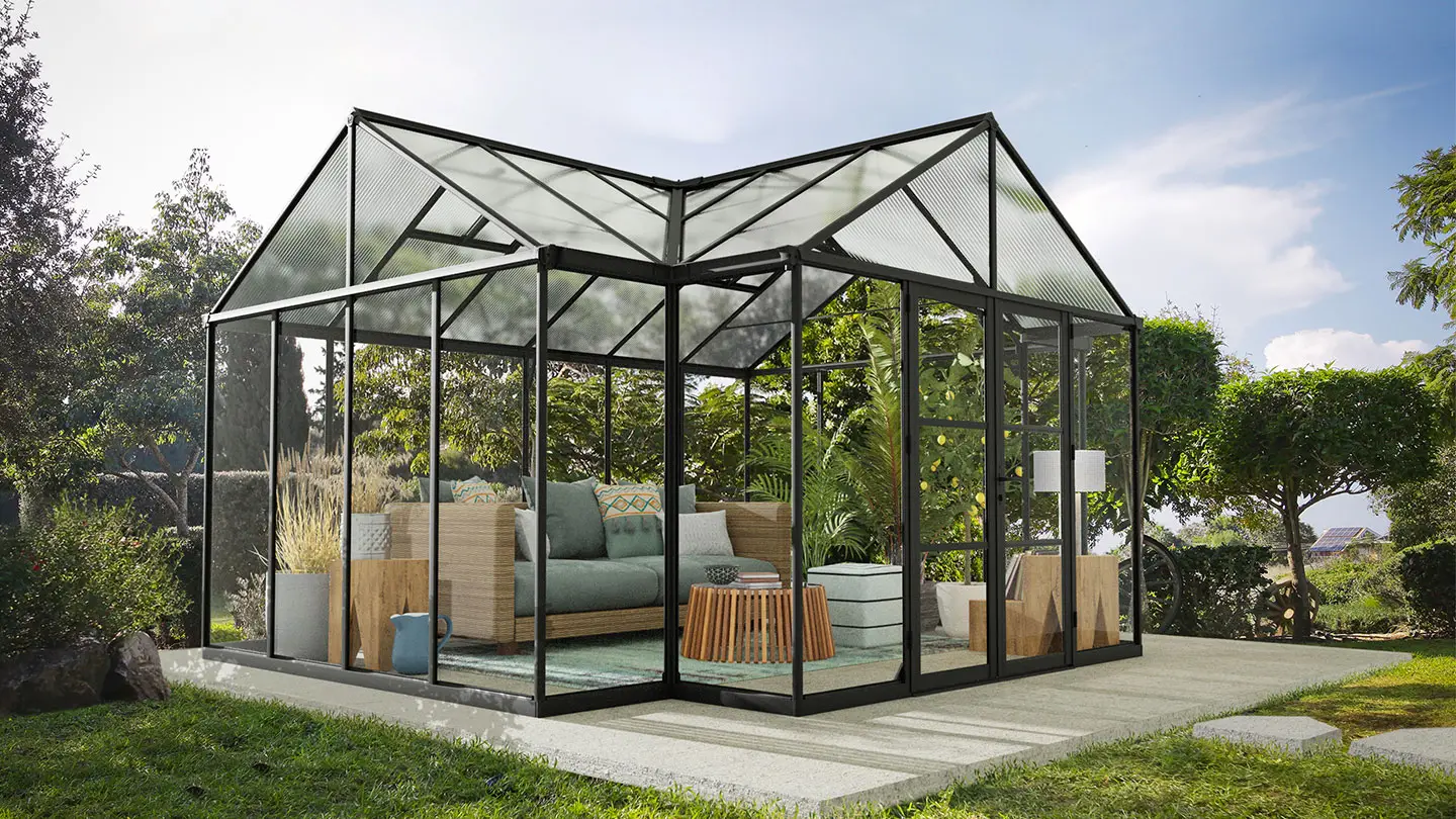 Black aluminum t-shaped greenhouse in a garden with furnitues inside